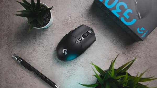 black logitech cordless computer mouse beside black pen