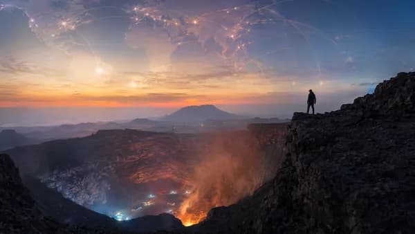 Dramatic Yemen volcanic crater with distant climber silhouette and subtle global connection map overlay.