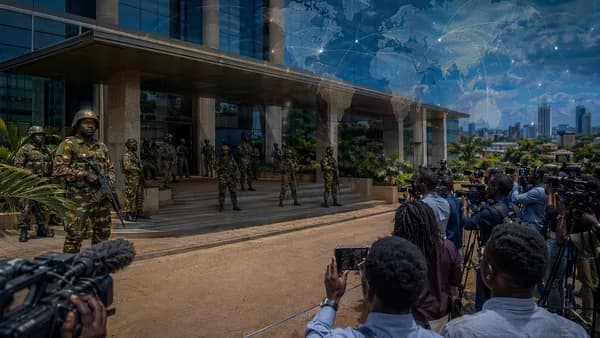 Soldiers outside an unbranded Ugandan newsroom, symbolizing a crackdown on press freedom.