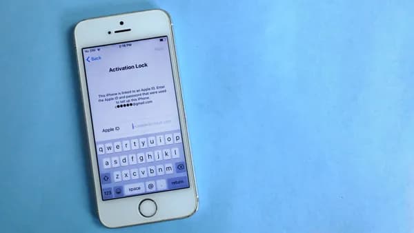 Top view of a smartphone showing activation lock screen on light blue surface.