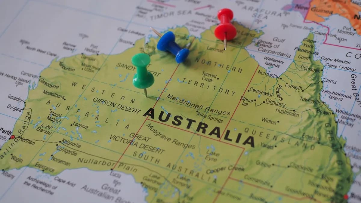 Close-up of a map of Australia featuring colorful pushpins marking locations.