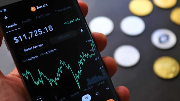 Close-up of Bitcoin trading app on smartphone showing market trends and digital coins.