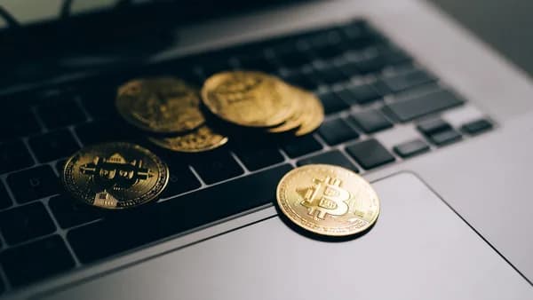 Close-up of golden Bitcoins placed on a laptop keyboard, symbolizing digital currency and modern finance.
