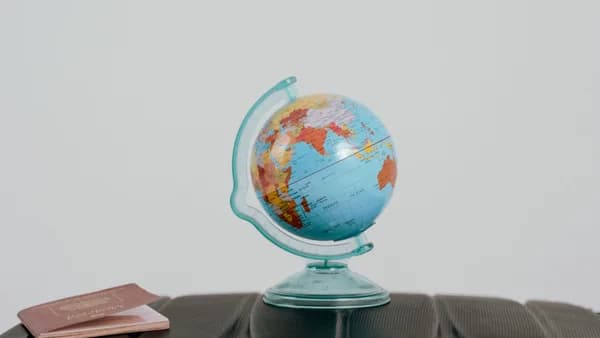 A globe and passport on a suitcase, symbolizing travel planning and wanderlust.