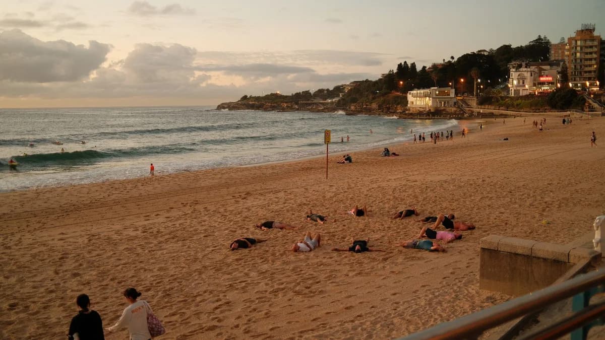 People relaxing on Bondi Beach during sunset, capturing a peaceful scene in Sydney, Australia.
