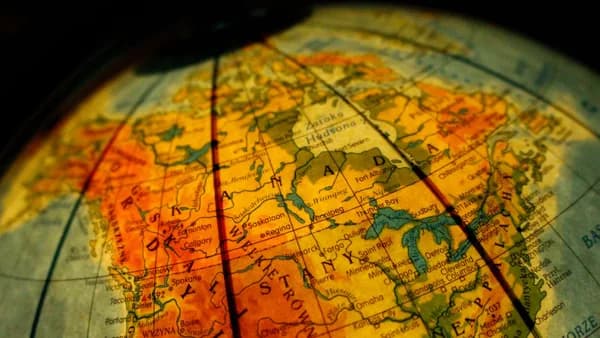 Close-up of a vintage globe focusing on Canada and the USA with a warm tone.