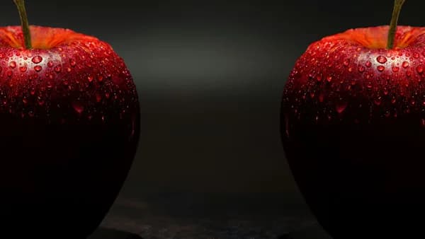 Vibrant red apples with dewdrops against a dark background, showcasing freshness.