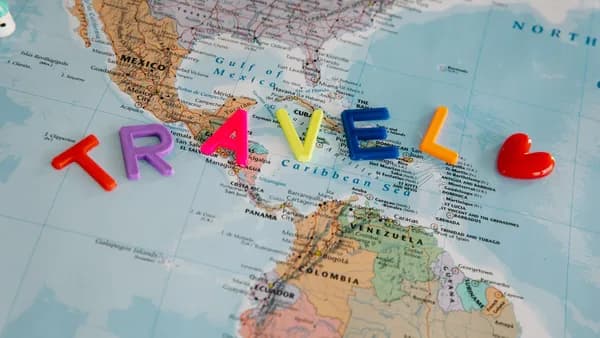 A vibrant map with colorful letters spelling 'TRAVEL', highlighting Central America and the Caribbean.