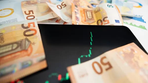 Close-up of 50 euro banknotes with a digital stock market chart on a tablet, depicting financial growth.