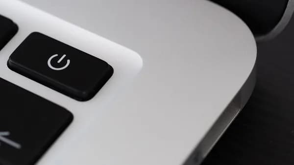 Detailed view of a power button on a sleek laptop, emphasizing technology design.