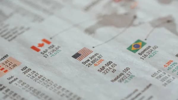 Detailed close-up of a newspaper displaying global financial market statistics and country flags.