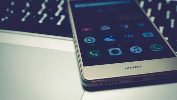 Close-up of a smartphone placed on a laptop keyboard, highlighting digital interaction.