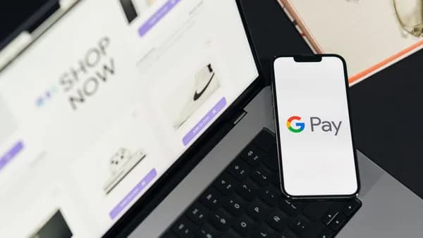 Smartphone with Google Pay on laptop for online shopping convenience.