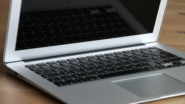Close-up of a modern, sleek laptop resting on a wooden desk, emphasizing its portability and design.