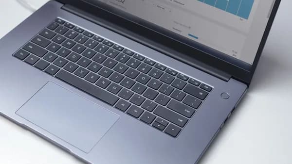 From above of modern portable computer with open analytical program on screen on white table