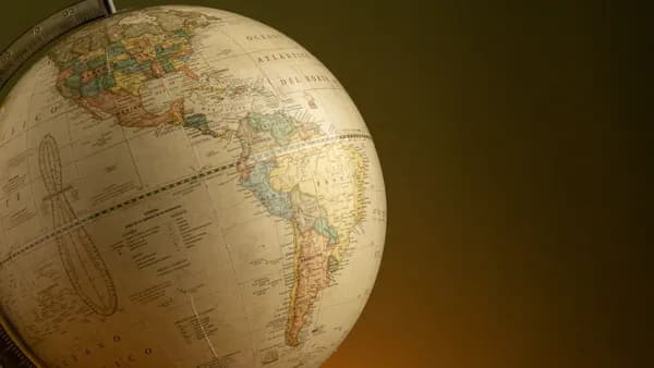 A vintage globe highlighting North and South America, set against a warm background.