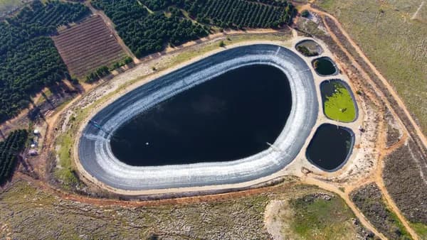Aerial shot of a reservoir and farmland showing irrigation ponds and planted fields.