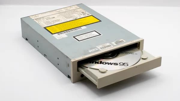 A vintage CD-ROM drive showcasing a Windows 95 disc, reflecting retro technology.
