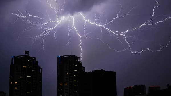 Stunning view of lightning bolts illuminating a cityscape at night, creating a dramatic and powerful scene.