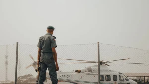 A military officer stands watch by an NAF helicopter fenced area in Nigeria.