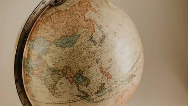 A vintage globe displaying the continents of Asia and Europe in sepia tones, ideal for travel concepts.