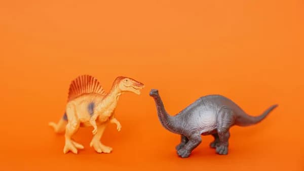 Miniature dinosaur toys in an orange setting showcasing prehistoric creatures.