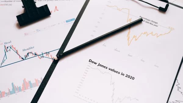Clipboard with stock market charts and graphs representing financial data analysis.