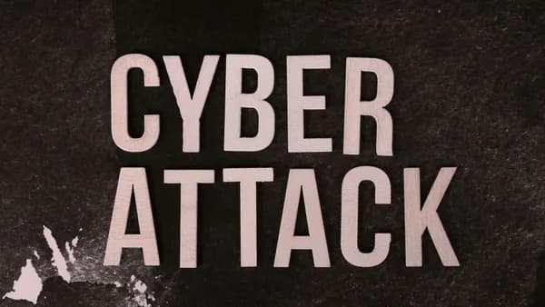 Text 'Cyber Attack' on textured dark paper highlights digital security threat concept.