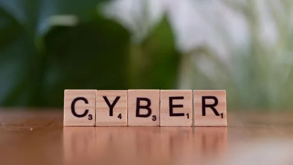 Wooden letter tiles spelling 'CYBER' on a blurred background, representing cybersecurity.