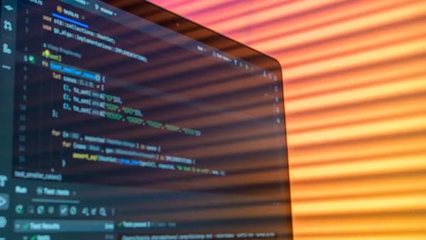 Close-up of computer code on a screen illuminated by warm lighting patterns, creating an artistic tech vibe.