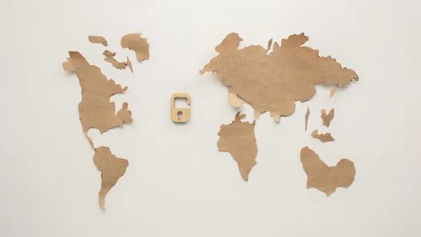 An artistic flat lay of a world map cutout accompanied by a padlock, symbolizing security.