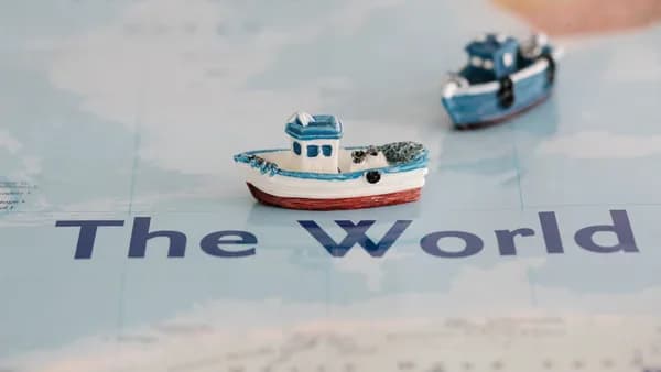 Close-up view of miniature ships placed on a world map, creating a nautical theme.