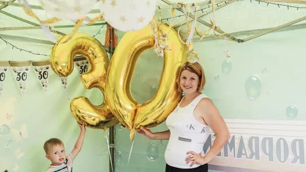 A cheerful 30th birthday party featuring gold balloons and decorations.