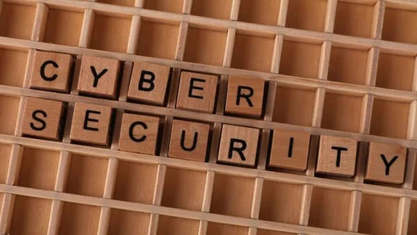 Wooden letter blocks spelling 'CYBER SECURITY' on a wooden grid background for data protection themes.