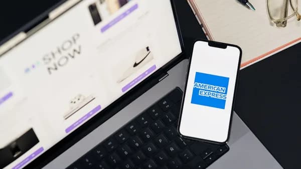 Smartphone displaying American Express logo on a laptop for online shopping convenience.