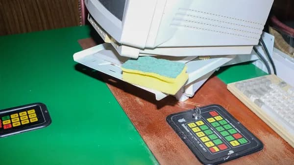 a computer monitor sitting on top of a desk next to a keyboard