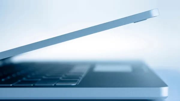 Profile view of a sleek modern laptop in a minimalist style, highlighting its slim design and technology focus.