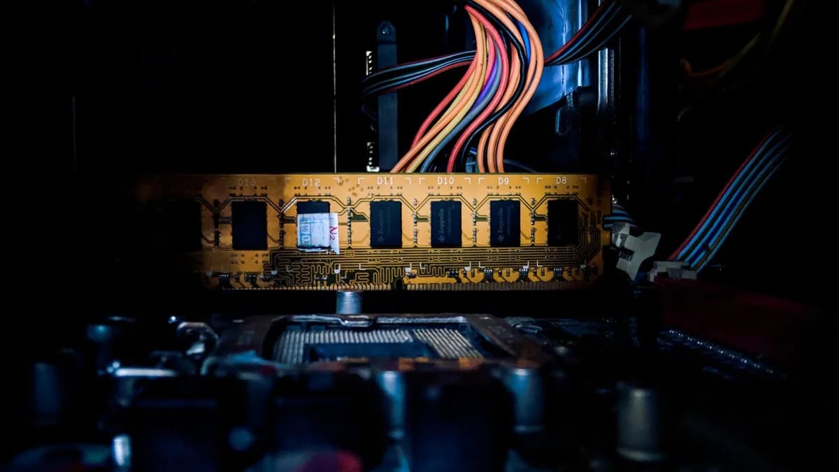 Detailed image of a computer circuit board with colorful cables and electronic components in low light.