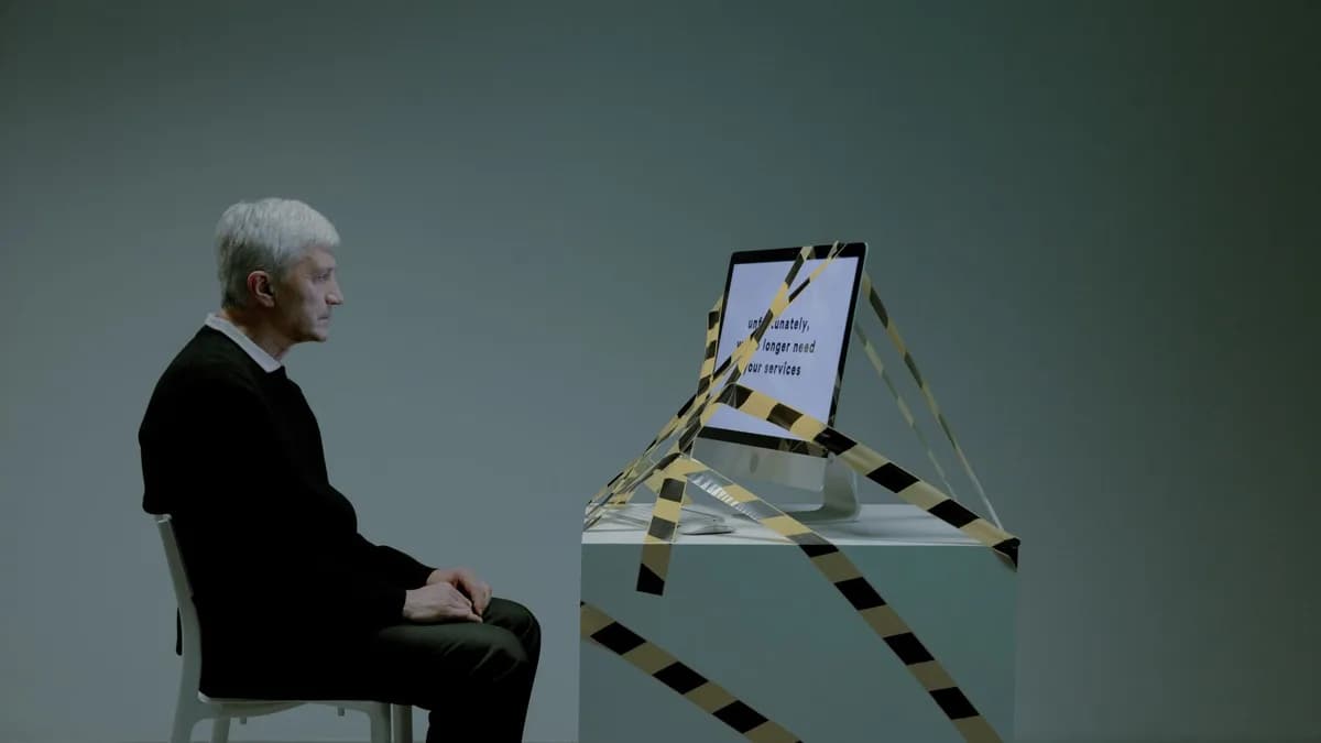 An elderly man sits contemplating job loss, surrounded by caution tape, symbolizing unemployment and ageism.