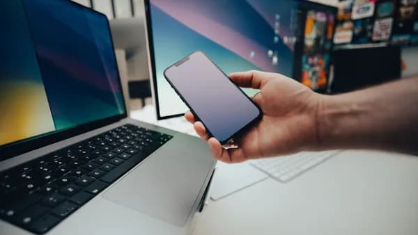 A contemporary workspace with a smartphone and laptop, showcasing modern technology in use.