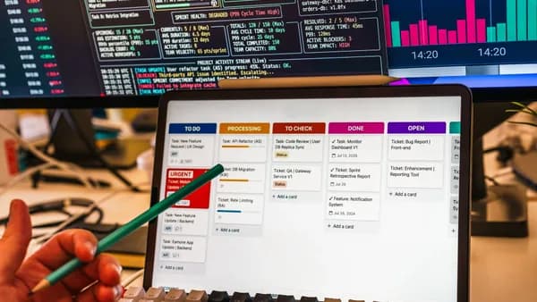 Detailed view of a business workflow setup with tablet and multiple screens displaying data charts.