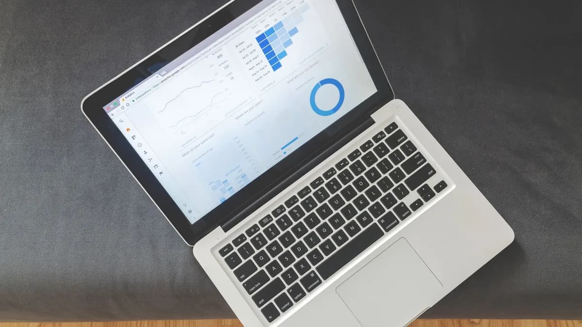 Overhead view of a laptop showing data visualizations and charts on its screen.