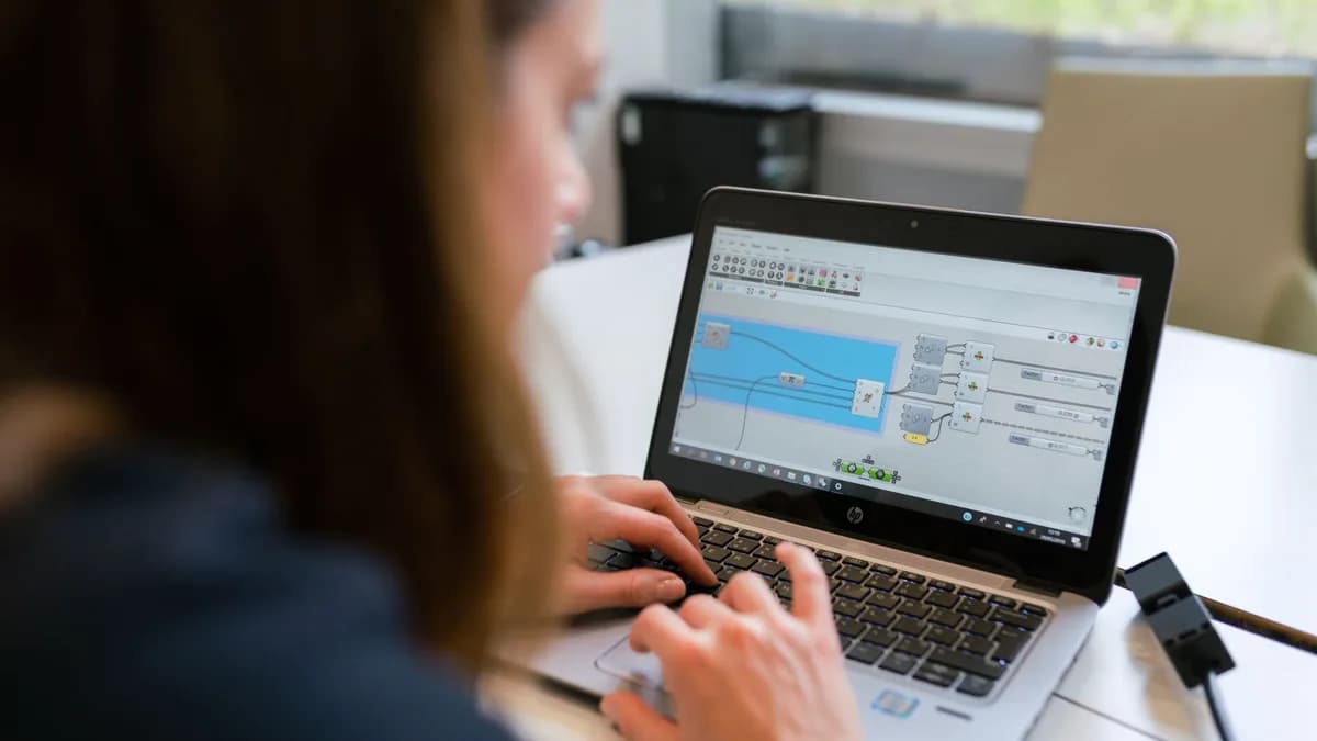 A woman engineer focuses on software analysis using a laptop indoors.