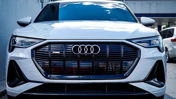 Sleek white Audi E-Tron SUV captured outdoors with a modern design.
