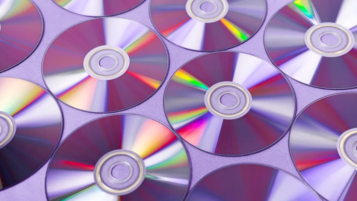 A vibrant arrangement of overlapping CDs reflecting colorful light patterns.