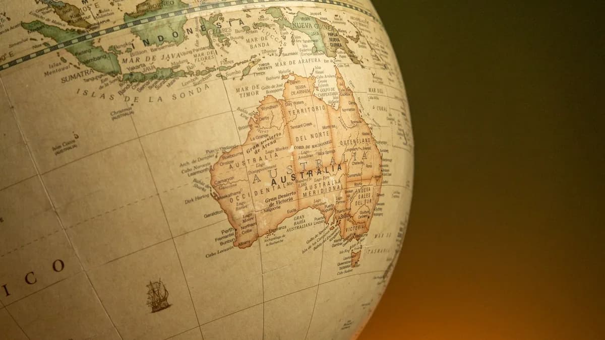 A close-up of a vintage map globe showcasing Australia and Indonesia against a warm background.