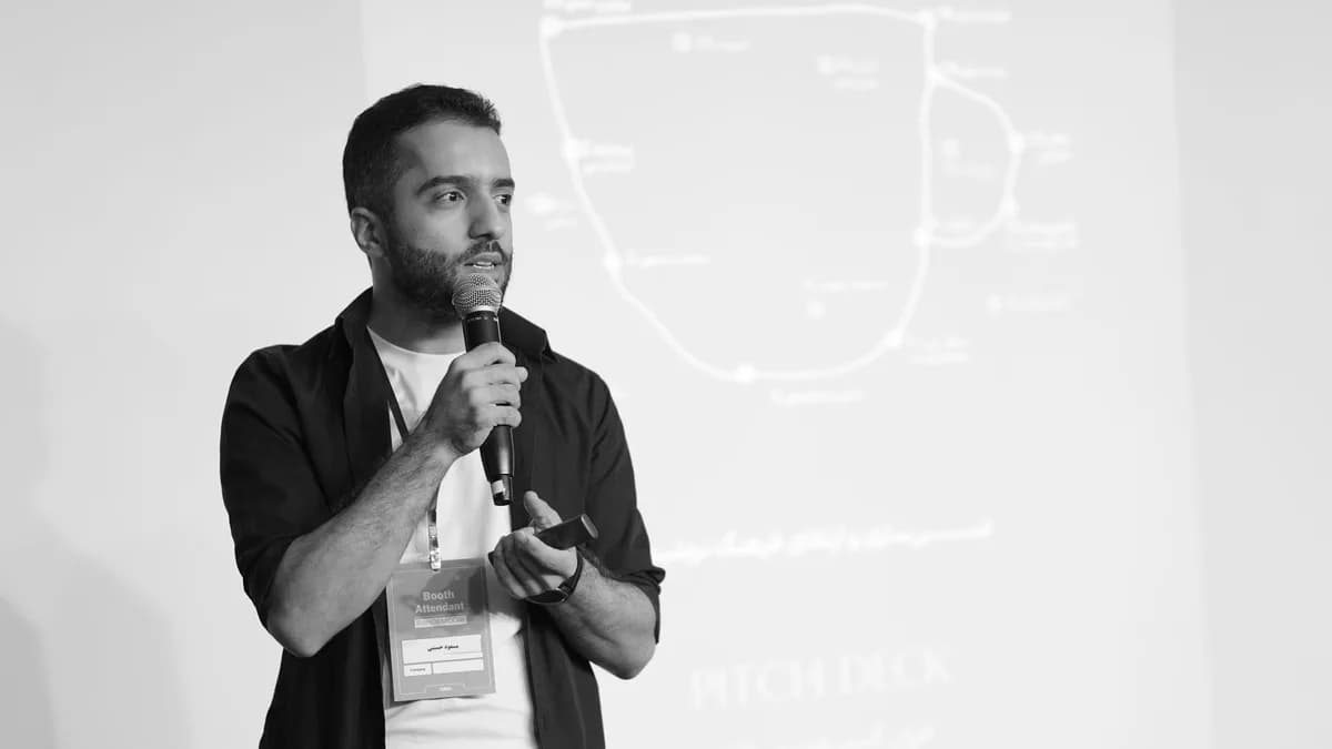 Man speaking into a microphone during a business seminar presentation.