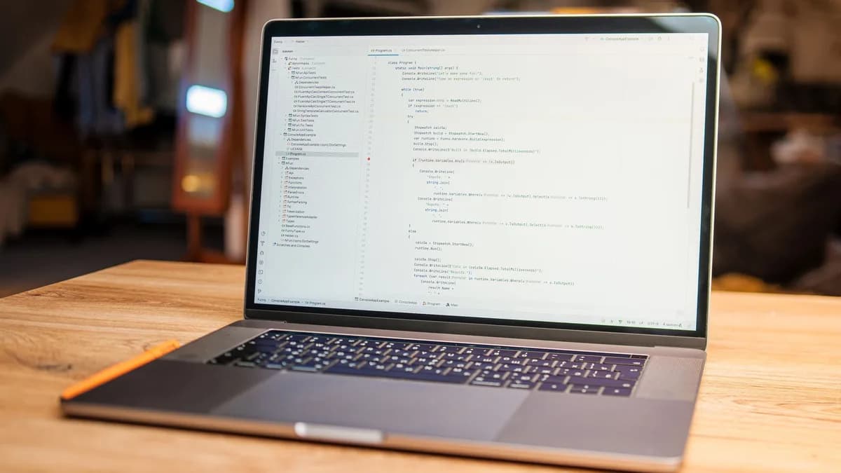 Open laptop with visible code on screen on a wooden desk in a modern, cozy workspace.