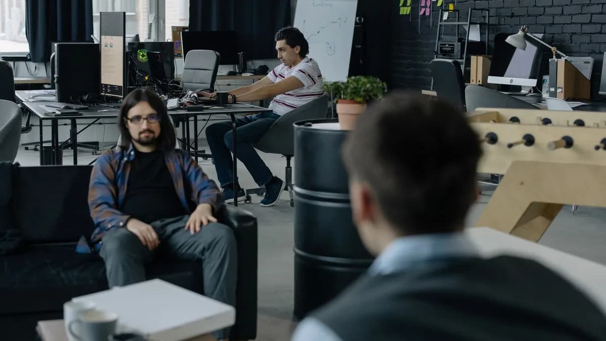 Team of professionals collaborating in a modern open office space with multiple workstations.