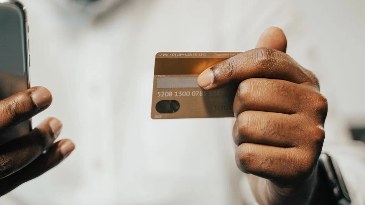 Person using a smartphone and credit card for online shopping or payment.